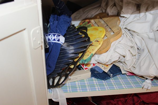 Tablecloths stuffed in a cabinet