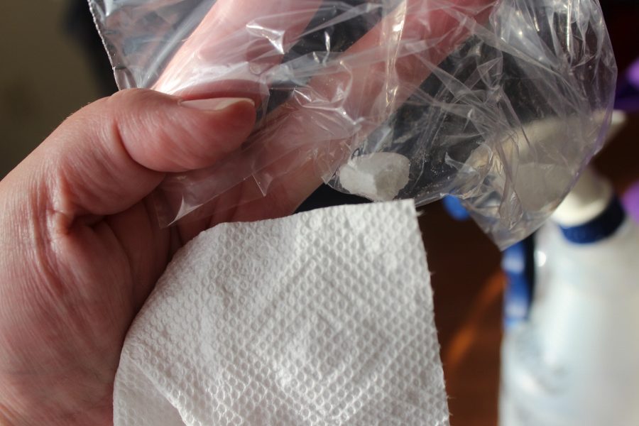 Breaking up the Clean Shot Bleach Tablet inside a plastic bag.