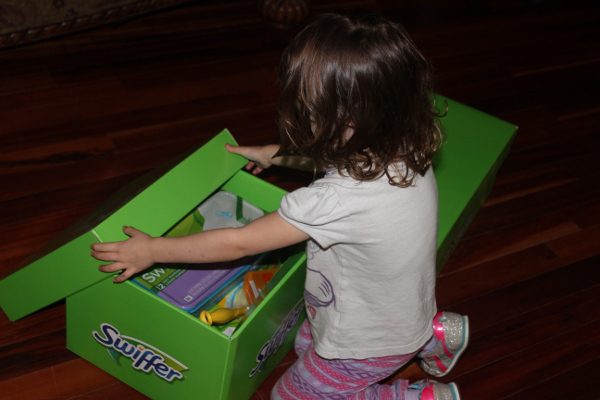 The daughter of my just-moved-in friend opening their Big Green Box of Swiffer fun! 